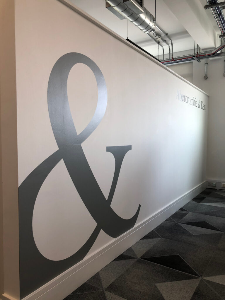 Large ampersand wall graphic printed for an office corridor