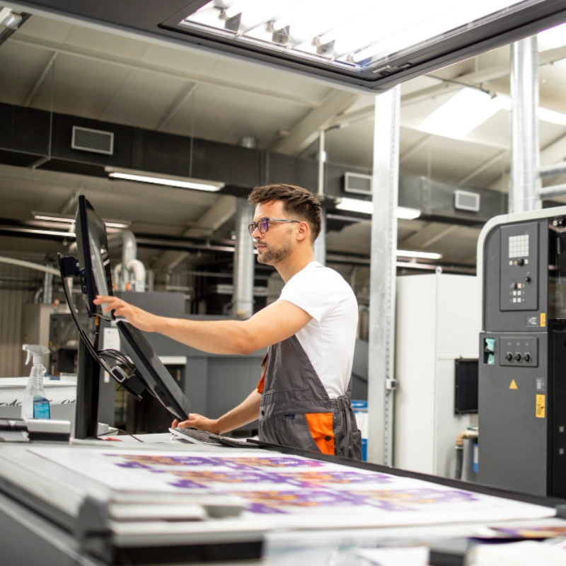 Typecraft operator checking sheets on a digital printing press in Cheltenham